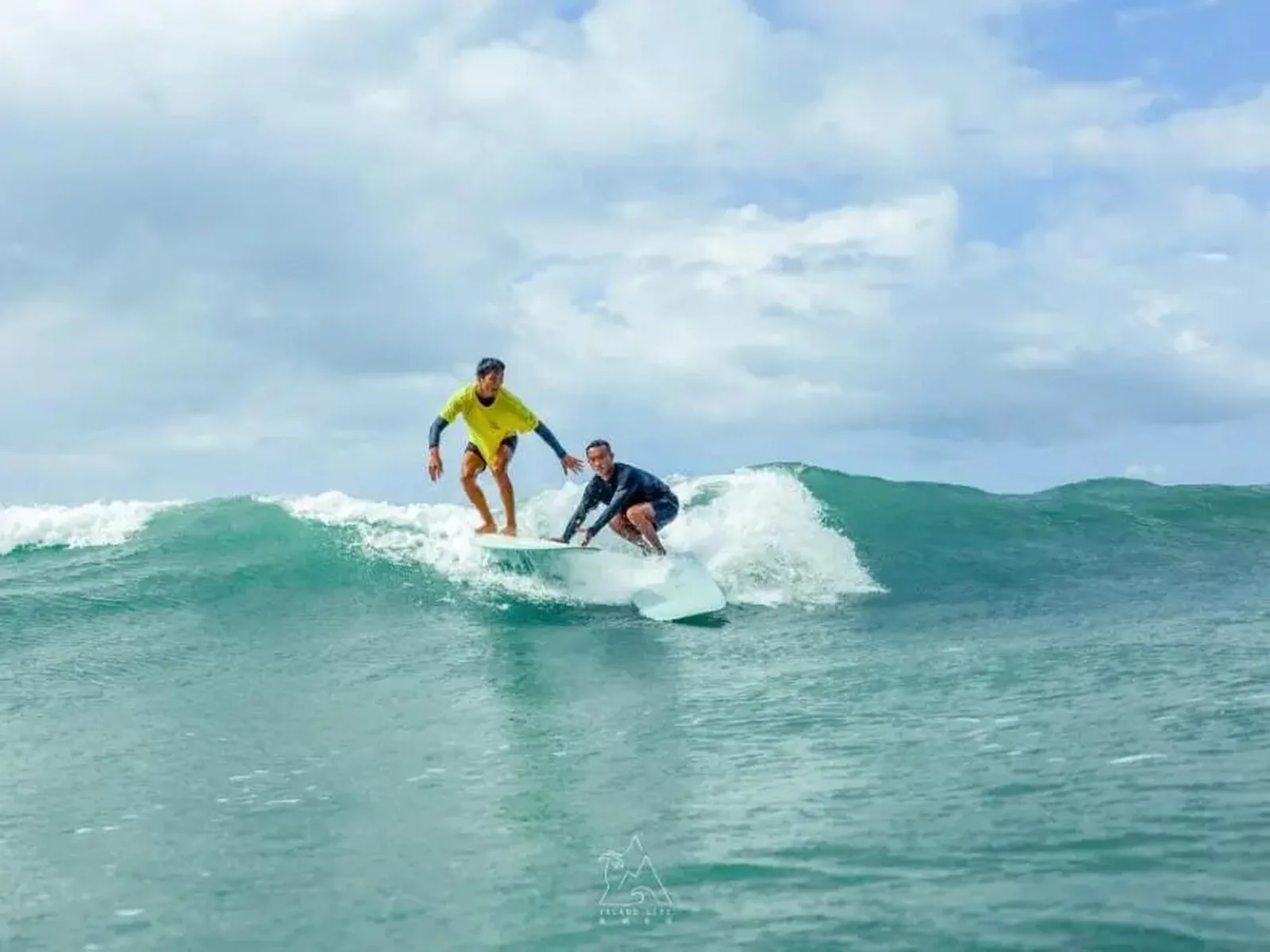 Travellers surfing on the clear blue sea off Hainan Island