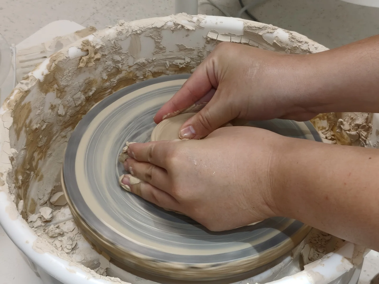 Hands shaping clay on a potter’s wheel in Jingdezhen
